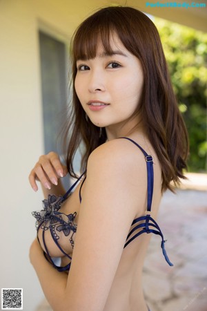 A woman in a pink lingerie posing for the camera.
