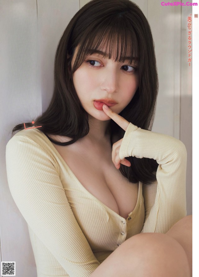 A woman in a white shirt is posing for a magazine cover.