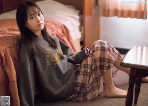 A woman laying on top of a bed next to another woman.