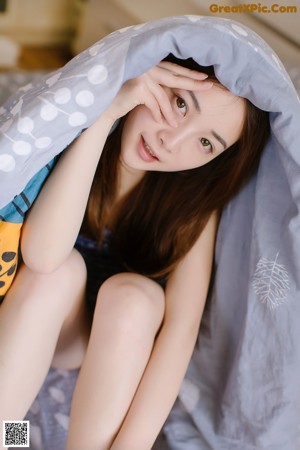 A woman in a blue dress sitting on the floor.