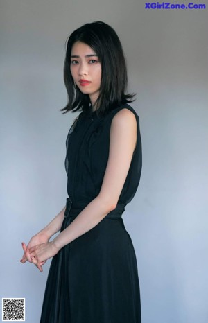 A woman with long black hair is posing for a picture.