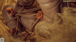 A woman tied up on a rope in a room.