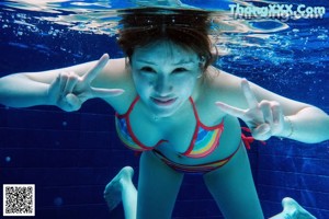 A woman in a blue swimsuit standing in a pool.