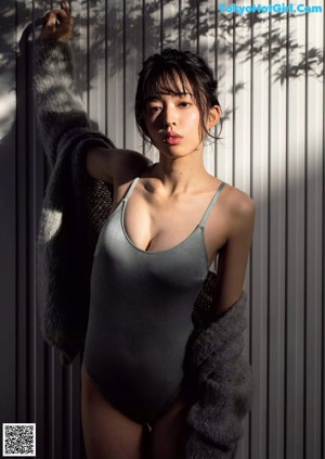 A woman in a blue bra and gray panties posing for a magazine.