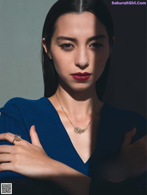 A woman wearing a gray sweater and a silver ring.