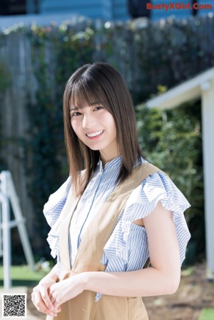 A woman in a striped shirt and jeans posing for a picture.