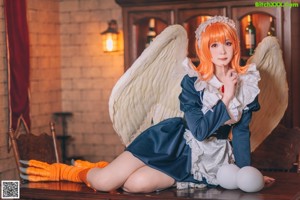 A woman dressed as an angel posing for a picture.