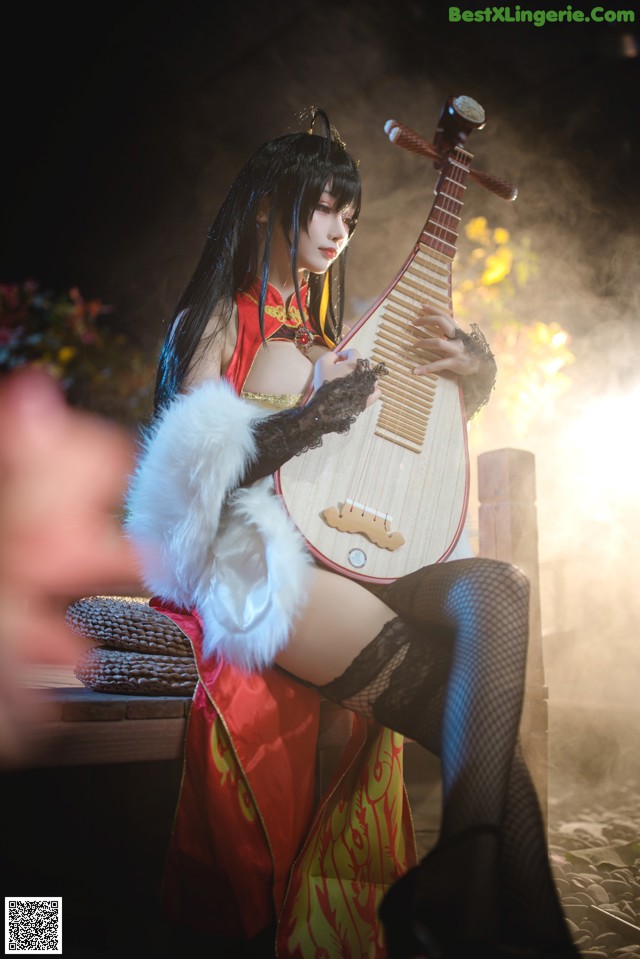 A woman in a red and black outfit playing a musical instrument.