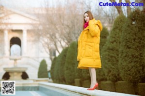 A woman standing next to a yellow sports car.