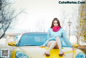 A woman sitting on top of a blue truck.