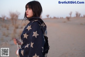 A woman wrapped in a blanket with stars on it.