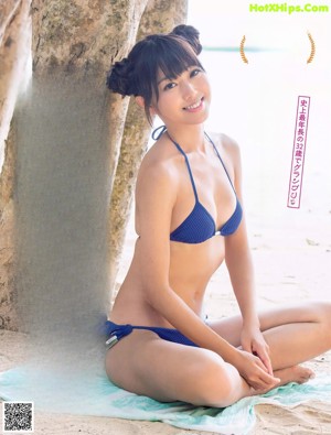 A woman in a bikini posing on the beach.