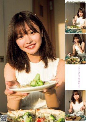 A woman holding a strawberry in front of her face.