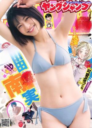 A woman in a gray bikini laying on a bed.