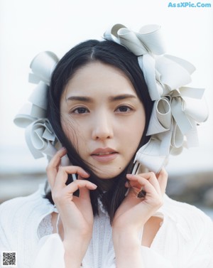 A woman in a white dress standing on top of a hill.