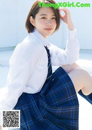 A woman in a school uniform is posing for a picture.