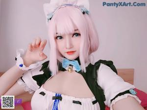 A doll with long pink hair wearing a black and white dress.