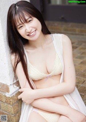 A woman in a yellow bra and panties posing for a picture.