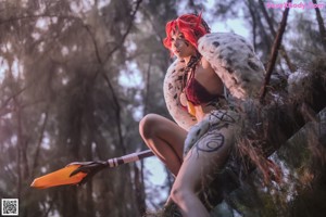 A woman with red hair holding a sword in her hand.