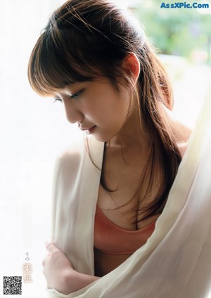 A woman in a white bra sitting on a chair.