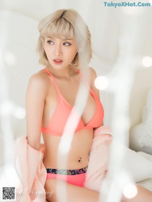 A woman in a pink dress posing for a picture.