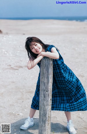 A woman sitting on the ground with her legs crossed.