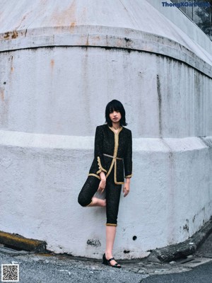 A woman standing in a hallway with her hands on her hips.